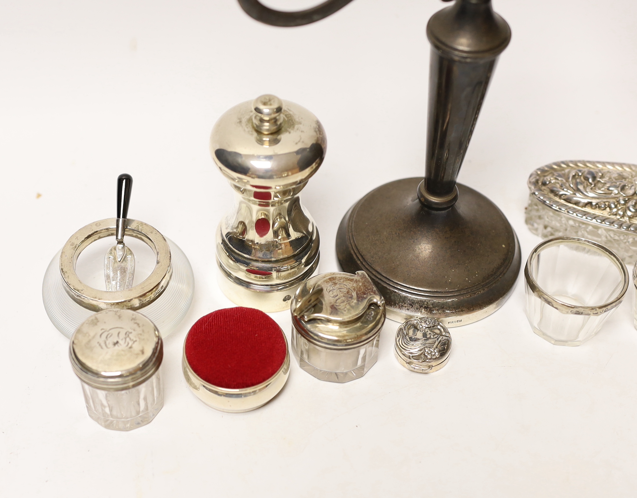 A group of mixed silver including a modern candelabrum, toilet jars and a pepper grinder.